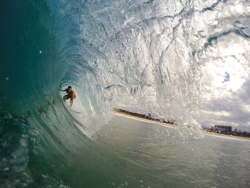 Surfer riding inside a massive ocean wave barrel