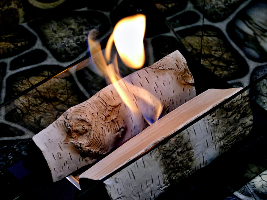 Burning birch logs in a modern glass fireplace