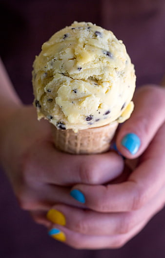 Close-up of hands holding a chocolate chip ice cream cone