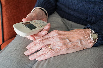 Close-up of elderly woman's hands holding a white cordless phone