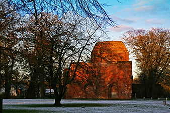 Sunlit Brick Monastery Ruin in Frosty Autumn Landscape