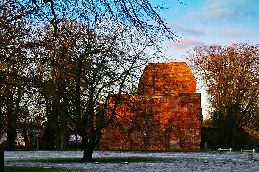 Sunlit Brick Monastery Ruin in Frosty Autumn Landscape