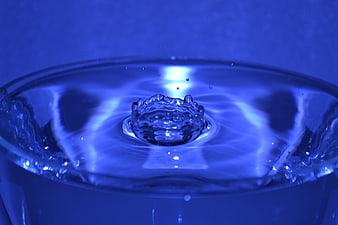 Blue water drop splash in glass close-up