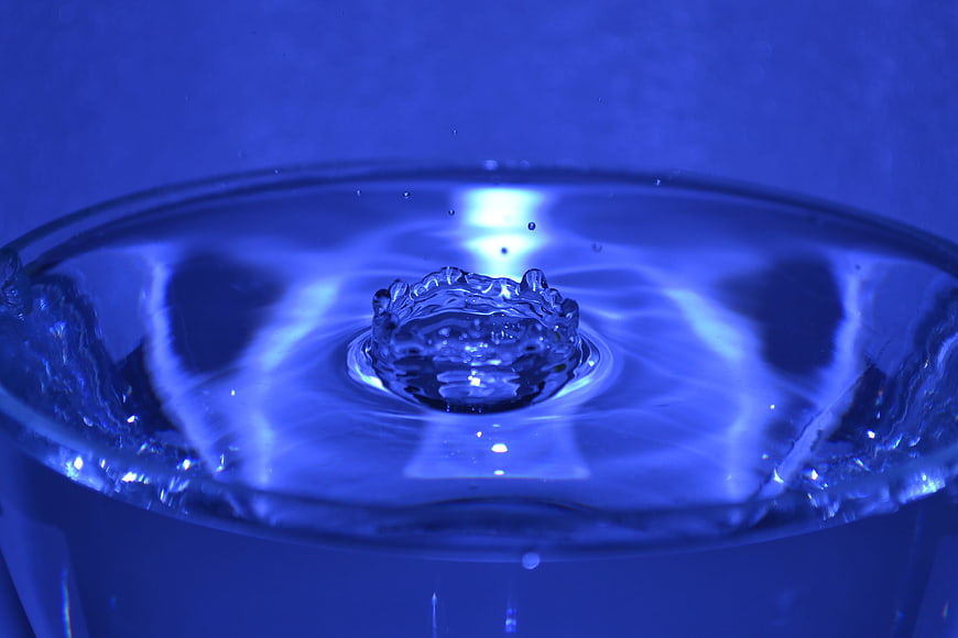 Blue water drop splash in glass close-up