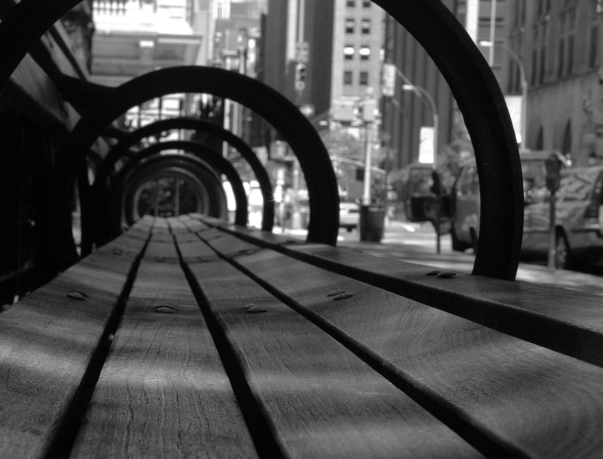 Black and white perspective of wooden city park bench