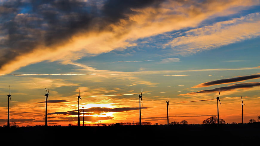 Silhouetted Wind Turbines Against Dramatic Sunset Sky