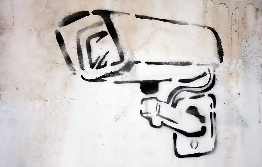 Black Spray Paint Graffiti of Surveillance Camera on Cracked Wall
