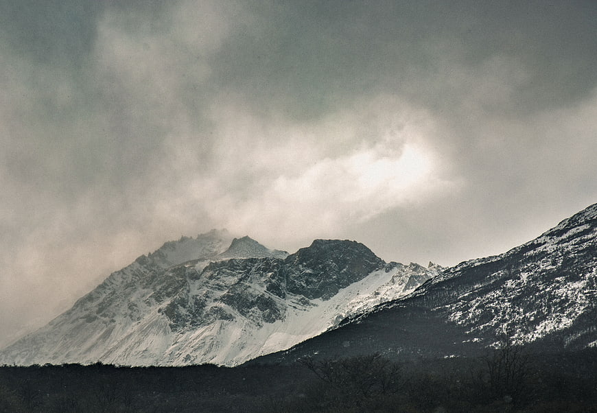 Dramatic Snow-Capped Mountain Peaks Under Cloudy Sky