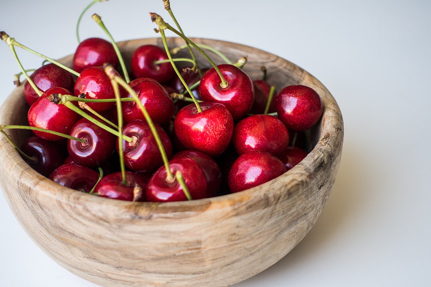 Fresh Red Cherries in a Wooden Bowl on White Background