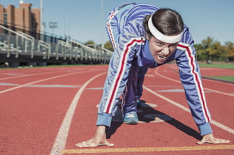 Female Sprinter in Starting Position on Red Track