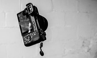 Black and white Sony camera on white brick wall
