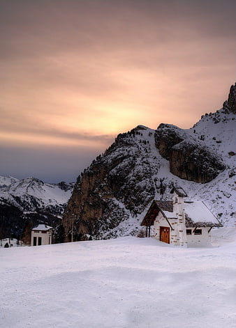 Alpine Mountain Cabin at Sunset in Snowy Winter Landscape