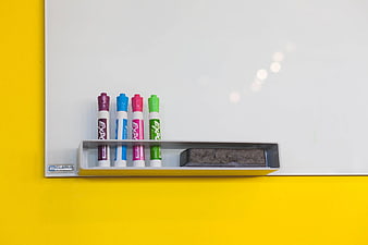 Colorful markers and eraser on whiteboard tray