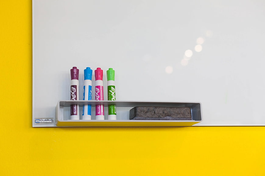 Colorful markers and eraser on whiteboard tray