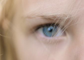 Close-up of blue eye with blonde hair strands