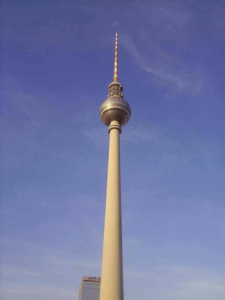 Berlin TV Tower against blue sky with parking building