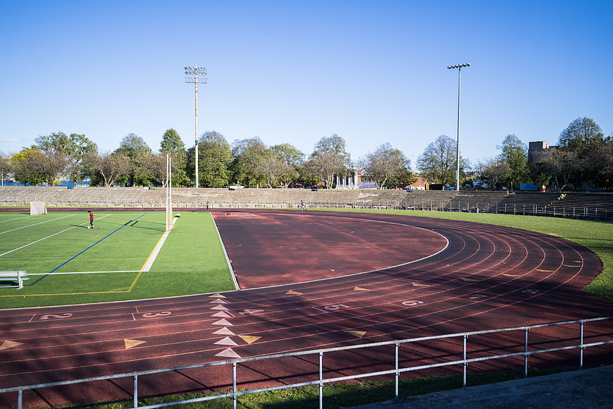 Empty athletic track and stadium field on sunny day