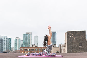 Woman doing yoga on city rooftop