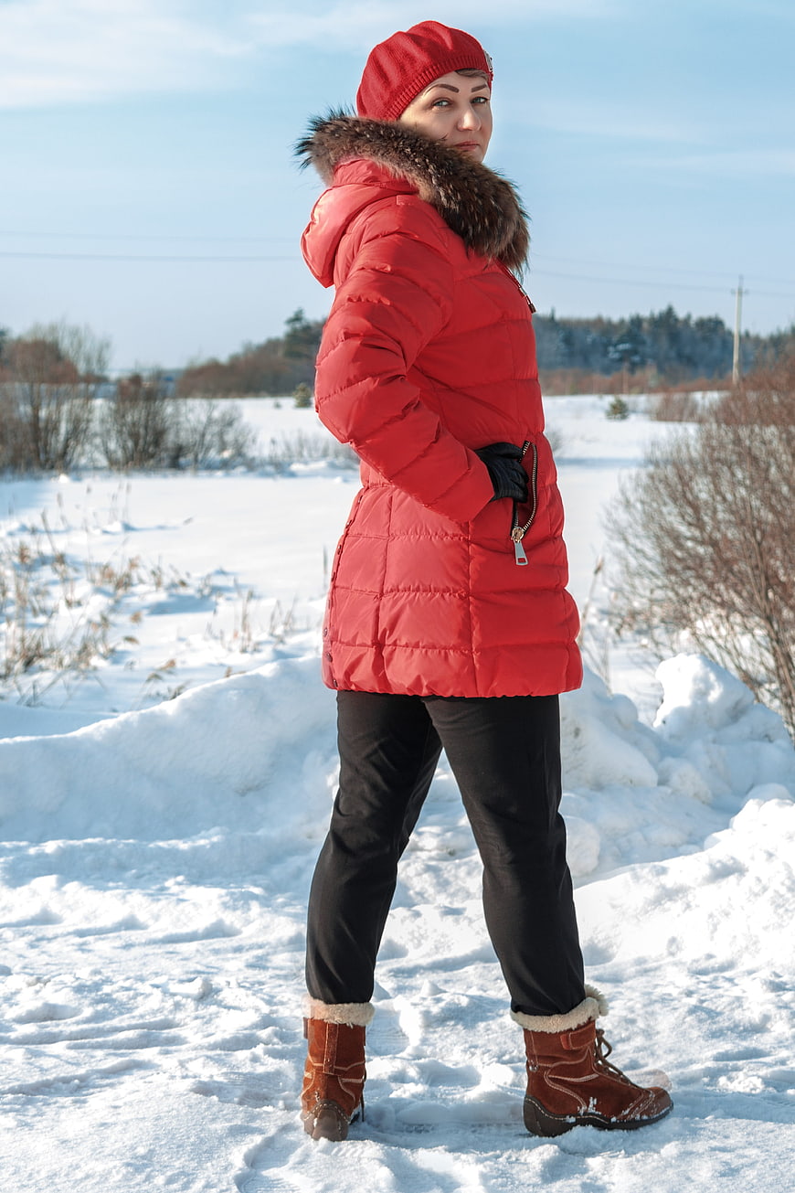 Woman in Red Winter Jacket Standing in Snowy Field
