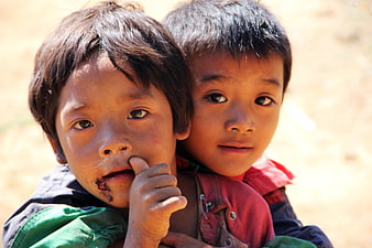 Close-up portrait of two young children with dirt on their faces