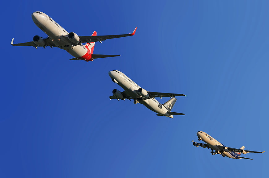 Three Commercial Airplanes Flying in Blue Sky