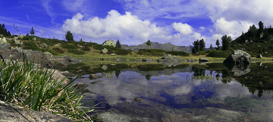 Panoramic Alpine Lake Reflection with Blue Sky and Mountains