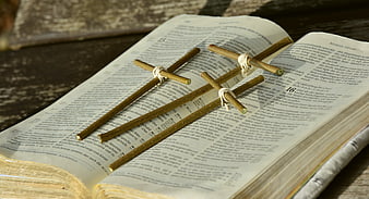 Three wooden crosses on open German Bible pages