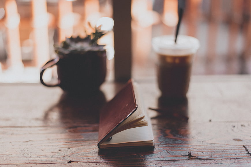 Leather Notebook and Iced Coffee on Rustic Wooden Table