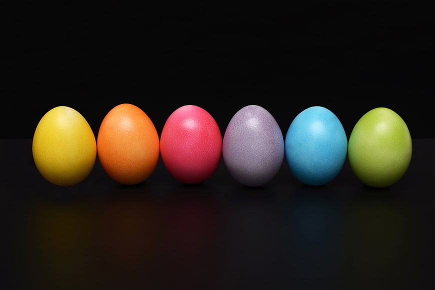 Row of colorful Easter eggs on black background