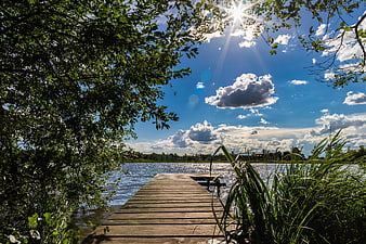Wooden Dock Extending Into Lake Under Blue Sky