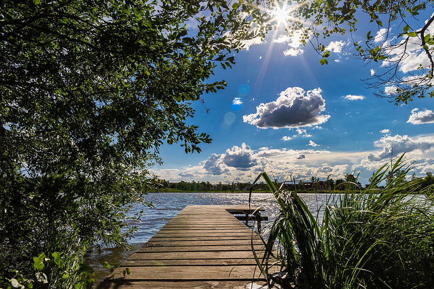 Wooden Dock Extending Into Lake Under Blue Sky