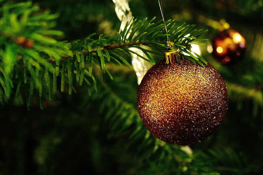 Gold Glitter Christmas Bauble Hanging On Fir Tree Branch