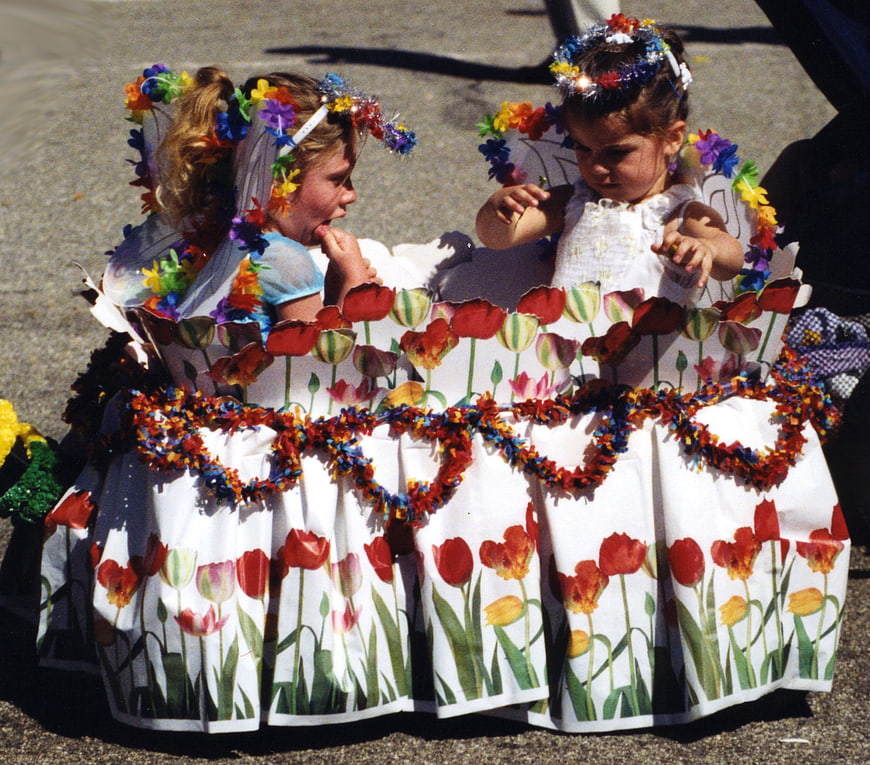 Two young girls in handmade flower costumes at a festival