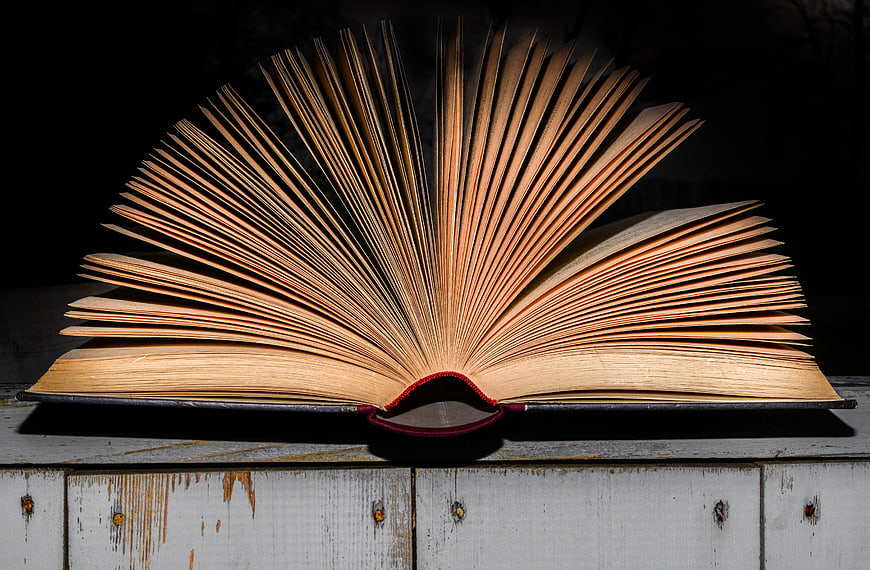 Open Book with Fanned Pages on Rustic Wooden Surface