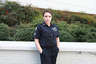 Female police officer in uniform standing outdoors