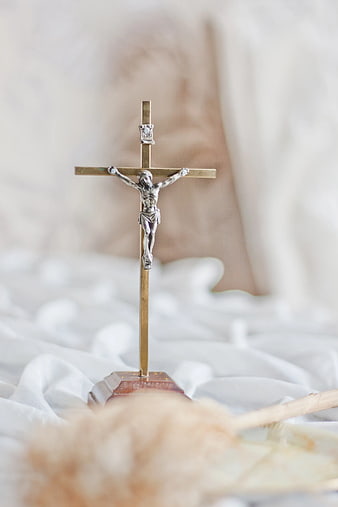 Silver Crucifix on White Fabric Background