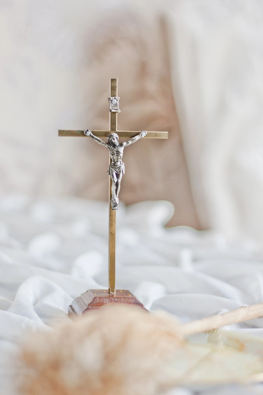 Silver Crucifix on White Fabric Background