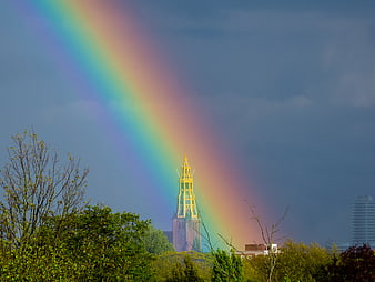 Vibrant rainbow arching over historic church tower in Groningen