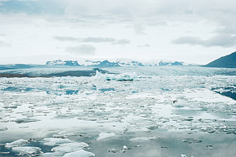 Glacial Lagoon with Floating Icebergs and Snowy Mountains