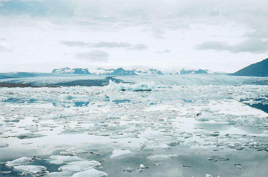 Glacial Lagoon with Floating Icebergs and Snowy Mountains