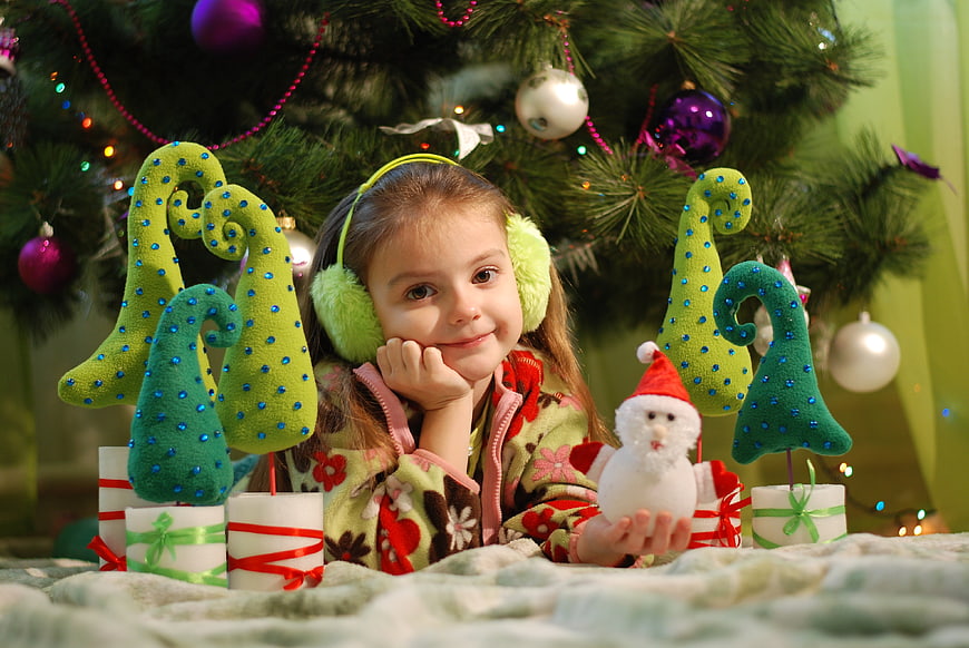 Cute Girl with Christmas Decorations and Snowman Toy
