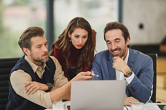 Business team collaborating on laptop in modern office