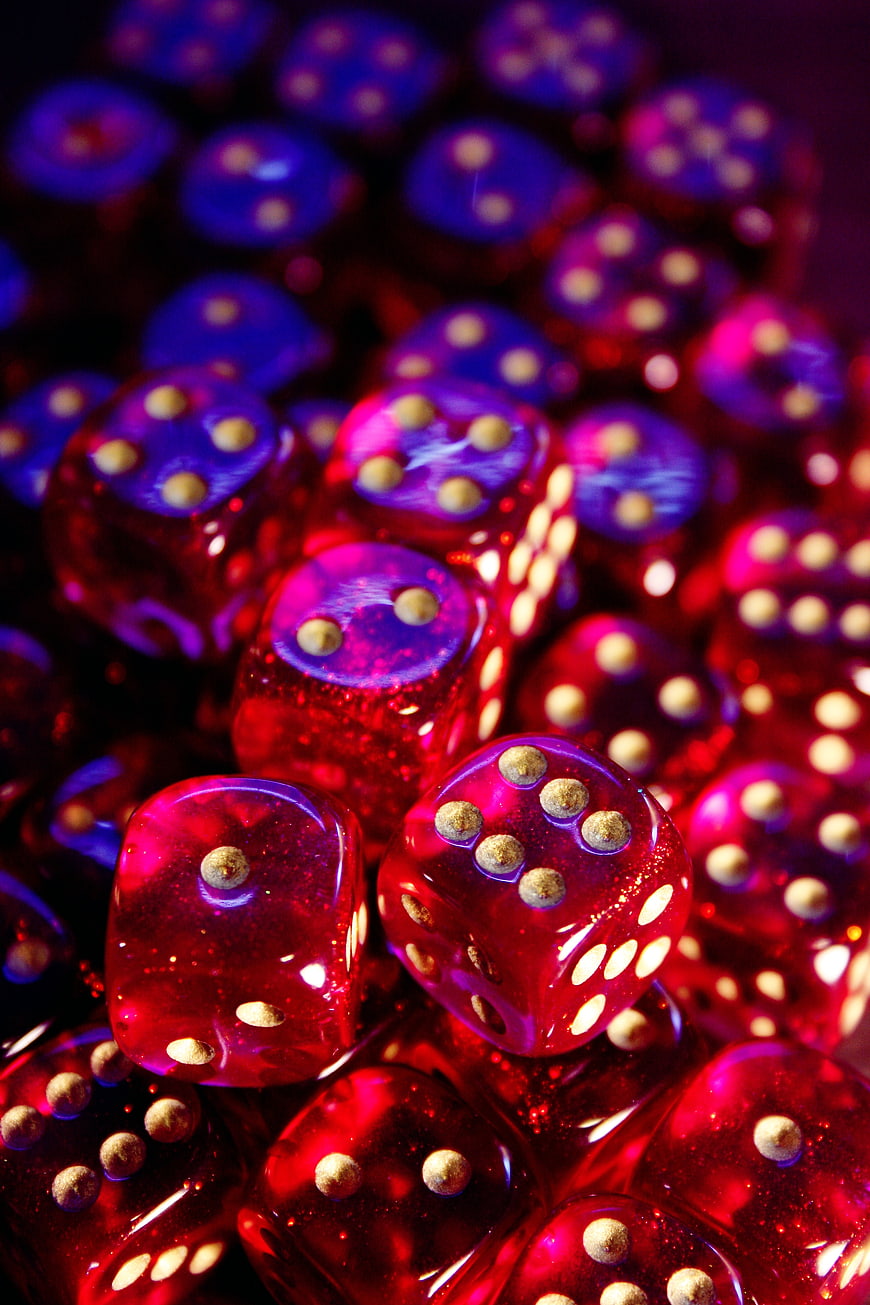 Close-up of translucent red and purple dice with gold pips