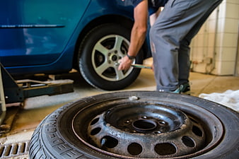 Mechanic Changing Car Tire in Auto Repair Shop