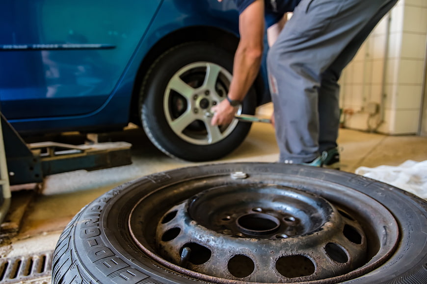 Mechanic Changing Car Tire in Auto Repair Shop
