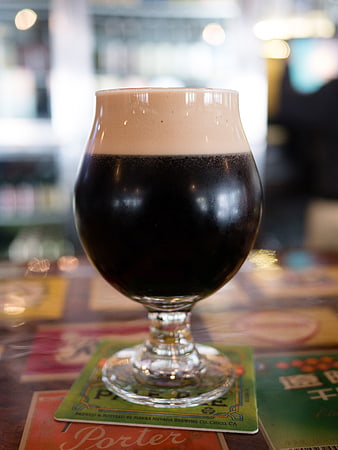 Dark stout beer in a tulip glass on a coaster