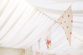 Pink polka dot bunting flags hanging in a white tent