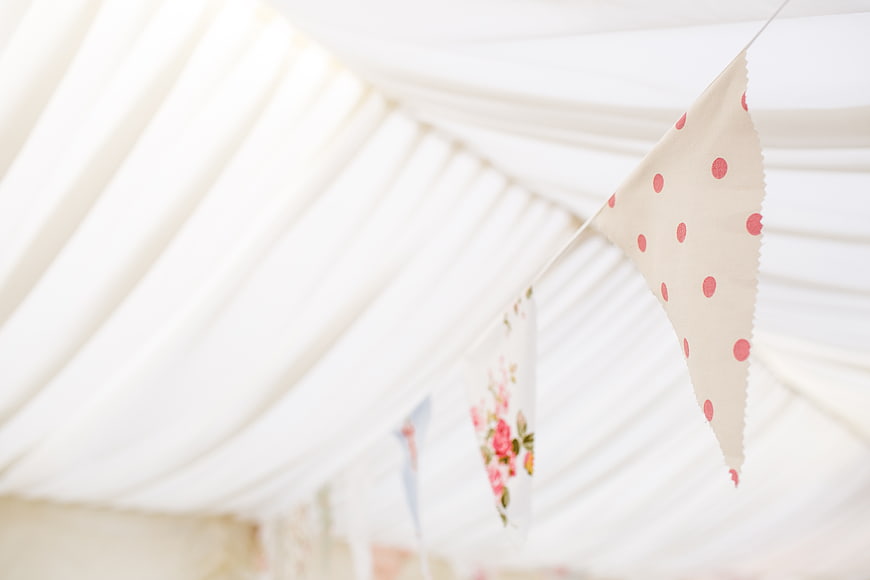 Pink polka dot bunting flags hanging in a white tent