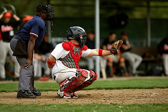 Baseball Catcher in Red Gear Receiving Pitch