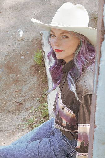 Portrait of woman with purple hair wearing white cowboy hat